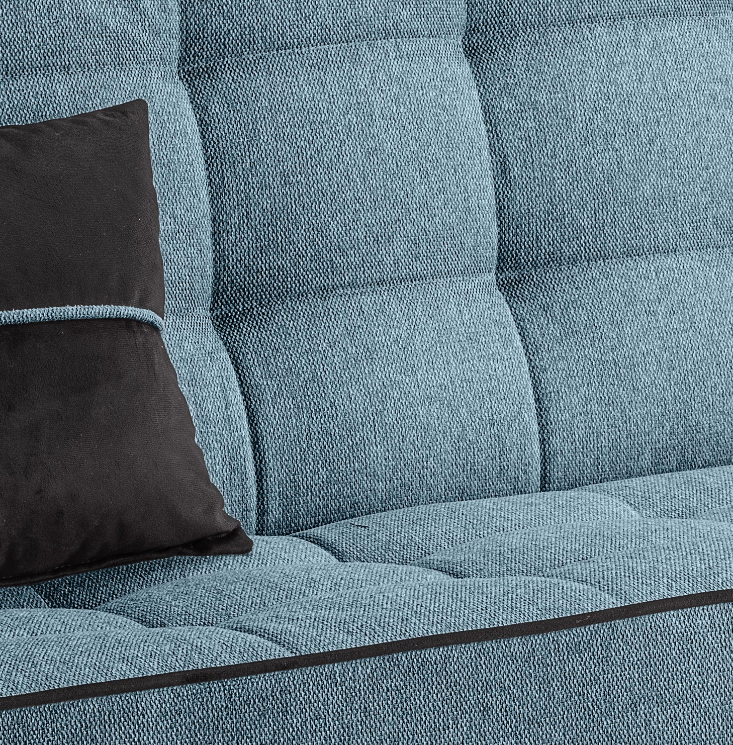 Polsterdetail am Schlafsofa: blaue Stoffoberfläche mit Quadersteppung und schwarzem Kissen