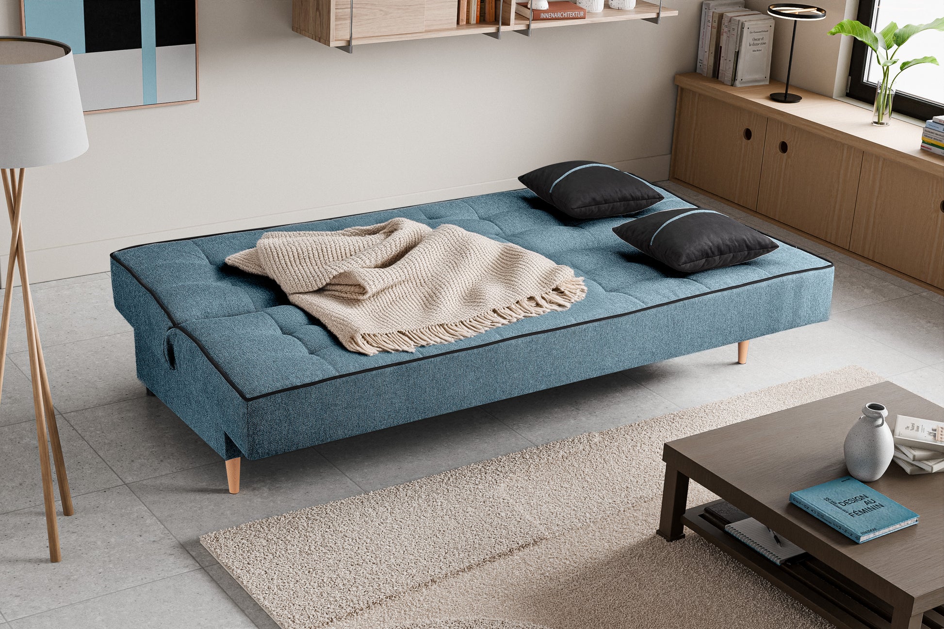 Schlafsofa mit Stoffbezug in Blau, aufgeklappt als Bett, mit zwei dunklen Kissen