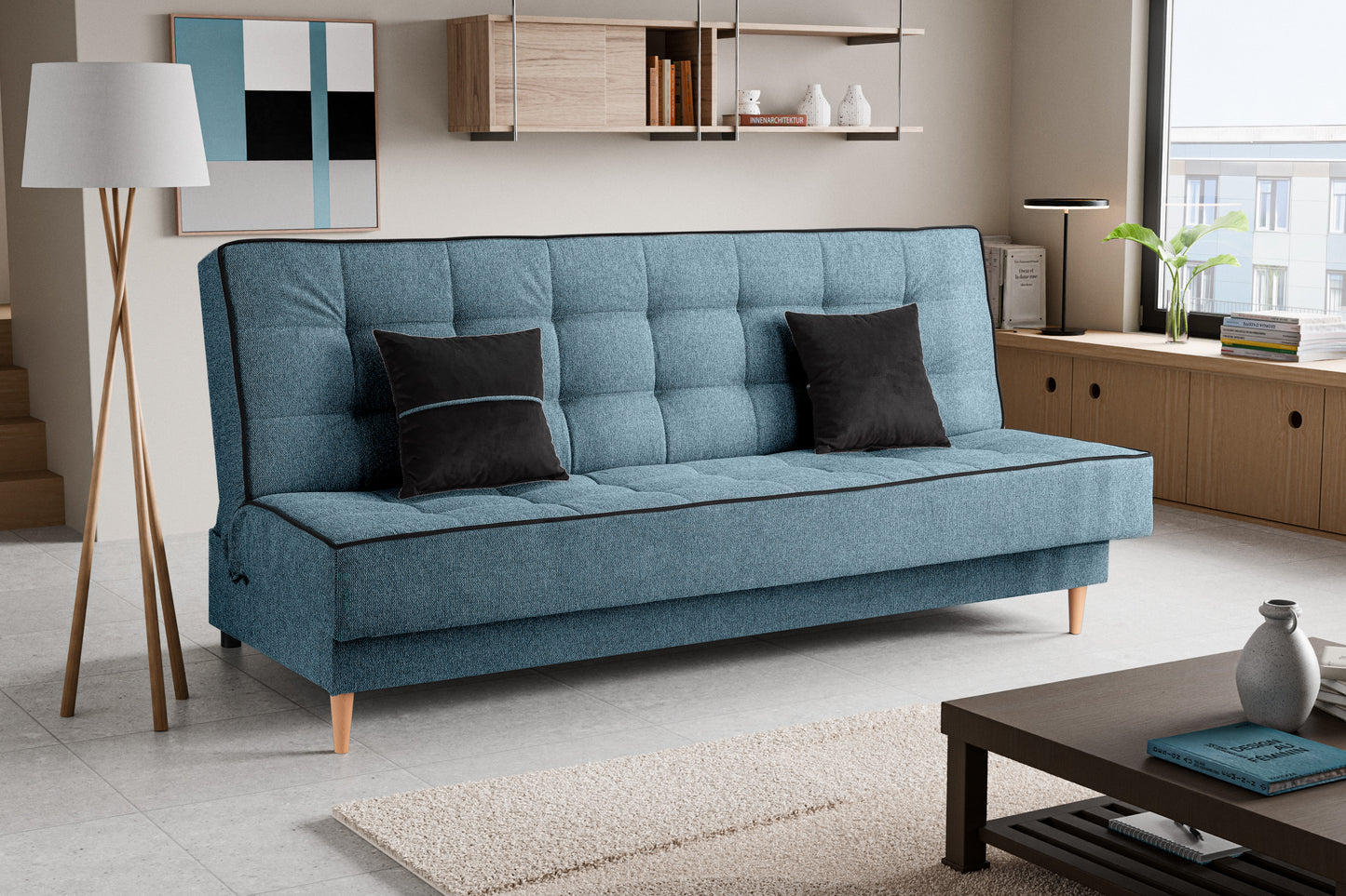 Schlafsofa mit blauer Polsterung und Quadersteppung, beidseitig zwei dunkle Zierkissen