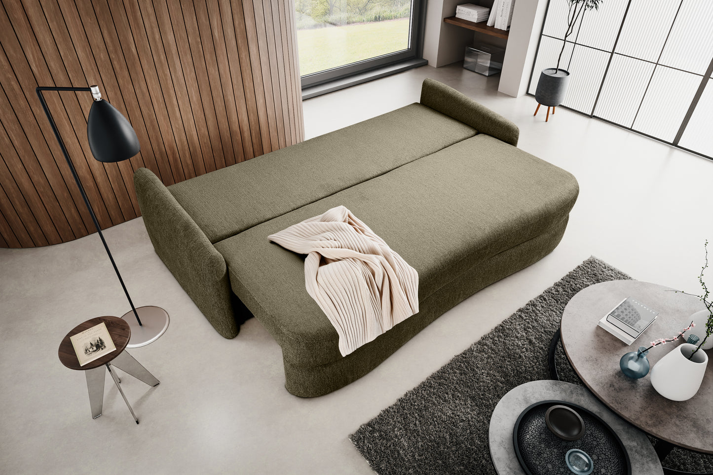Schlafsofa mit ausgeklappter Liegefläche, olivgrünem Polster und gerollter Decke